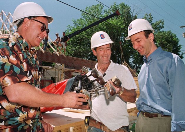 Gregory Nixon, a la izquierda, entrega un juego de palos de golf antiguos que vendió a David Robichaud, en el centro, a través de Subastas de Amazon.com en 1999. Bezos estaba allí por el momento, ya que Robichaud, un trabajador de la construcción, era el cliente número 10 millones de Amazon. Paul Connors / AP