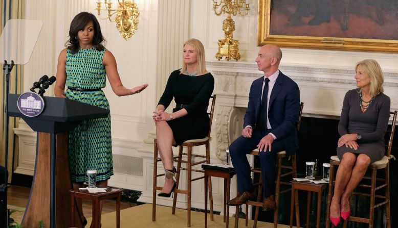 Bezos escucha a la primera dama Michelle Obama en un evento de la Casa Blanca en 2016. El evento anunció compromisos de más de 50 empresas para contratar y capacitar veteranos y cónyuges de militares. Bezos anunció el compromiso de Amazon de contratar a 25.000 veteranos militares más en los siguientes cinco años. Chip Somodevilla / Getty Images