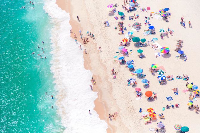Sombrillas de colores, bañistas alegres y hermosas olas del mar decoran esta imagen del East Hampton, tomada en 2019.