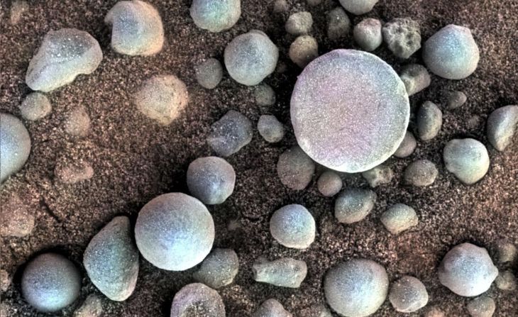 Estas pequeñas solidificaciones ricas en hematita están cerca del cráter Fram, visitado por el rover Opportunity de la NASA en abril de 2004. El área que se muestra tiene 3 centímetros de ancho. La foto proviene del generador de imágenes microscópicas en el brazo robótico de Opportunity, con información de color agregada desde la cámara panorámica del rover. Estos minerales sugieren que Marte tuvo un pasado acuoso.