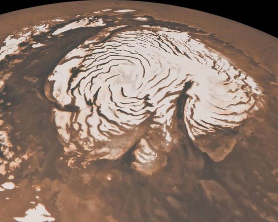 Esta imagen, que combina datos de dos instrumentos a bordo del Mars Global Surveyor de la NASA, muestra una vista orbital de la región polar norte de Marte. El casquete polar rico en hielo tiene casi 1.000 kilómetros de ancho y las bandas oscuras son valles profundos. A la derecha del centro, un gran cañón, Chasma Boreale, casi divide la capa de hielo. Chasma Boreale tiene aproximadamente la longitud del famoso Gran Cañón de los Estados Unidos y hasta casi 2 kilómetros de profundidad.