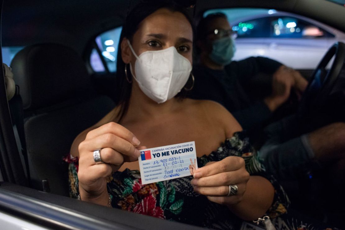 Una mujer muestra su tarjeta de vacunación contra el covid-19 en el parqueadero de un centro comercial en Santiago. El país de de 19,2 millones de personas ha ordenado 90 millones de dosis a Pfizer, AstraZeneca, Sinovac y Johnson & Johnson.