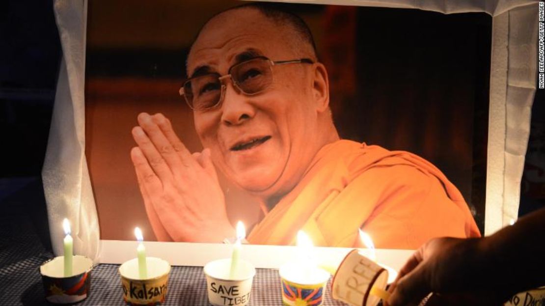 Un activista tibetano enciende una vela frente a un cartel del líder espiritual Dalai Lama mientras miembros del Congreso Regional de la Juventud Tibetana (RTYC) participan en una vigilia con velas durante una manifestación de protesta en Hyderabad el 10 de marzo de 2016.