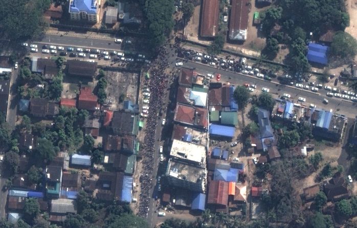 Otra fotografía, tomada el 13 de febrero, muestra la importante presencia de manifestantes en las calles de Myitkyina, la capital del atribulado estado de Kachin. Los manifestantes están en un lado de la calle, llenando el carril de más de una cuadra de longitud, el tráfico bloqueado levemente por su paso. Imagen de satélite © 2021 Maxar Technologies