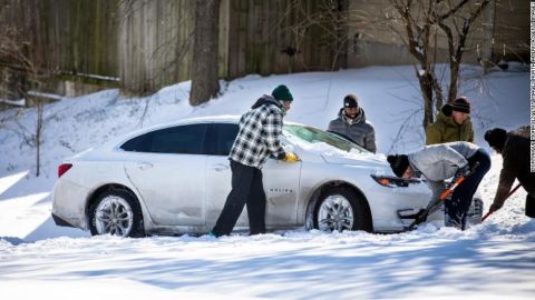 Un hombre saca nieve de debajo de un automóvil atascado el 15 de febrero de 2021 en East Austin, Texas. Las fuertes tormentas invernales provocaron un tiempo frío histórico en Texas, lo que llevó a apagones y cortes de agua.