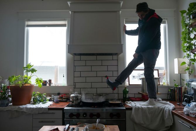 Jorge Sanhueza-Lyon se para en la encimera de su cocina para calentarse los pies sobre su estufa de gas en Austin. Ashley Landis / AP