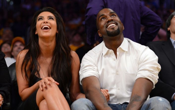 Kim y Kanye miran al tablero de un partido de la NBA, mientras están sentados entre los asistentes en Los Ángeles en mayo de 2012.