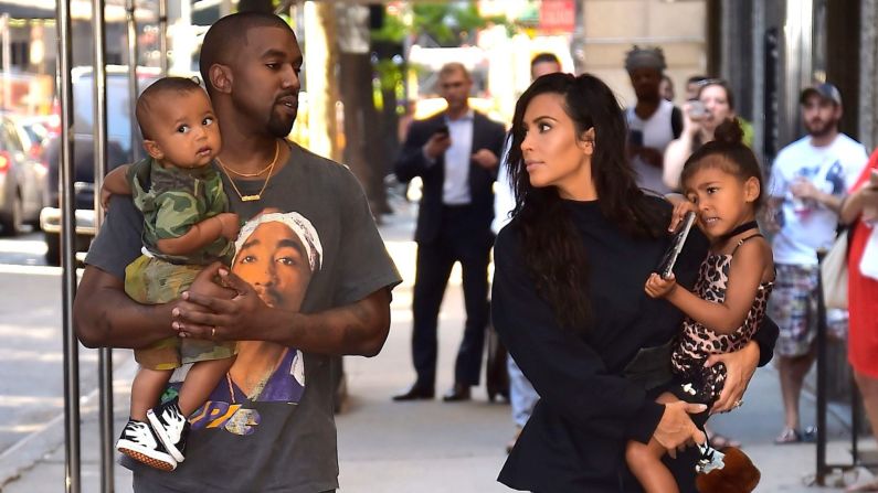 Kanye sostiene a su hijo Saint y Kim carga a North mientras caminan en Nueva York en agosto de 2016.