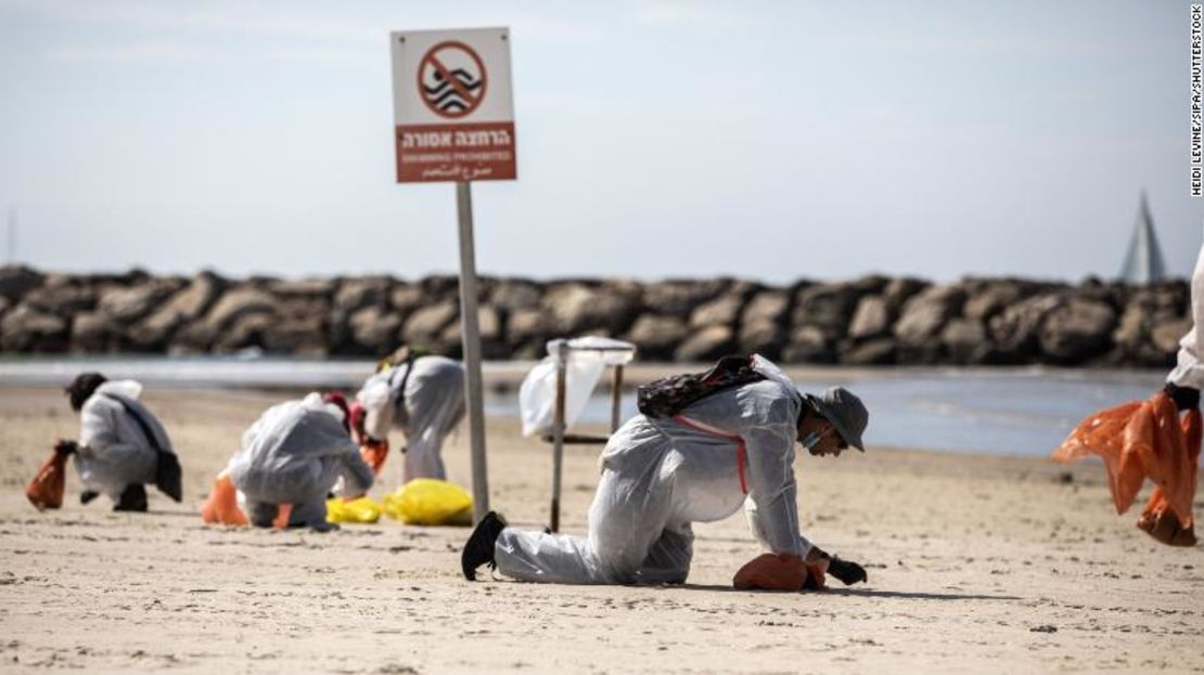 Voluntarios con ropa protectora buscan alquitrán a lo largo de la costa de Israel en Herzilya Pituah, al norte de Tel Aviv, el 21 de febrero.