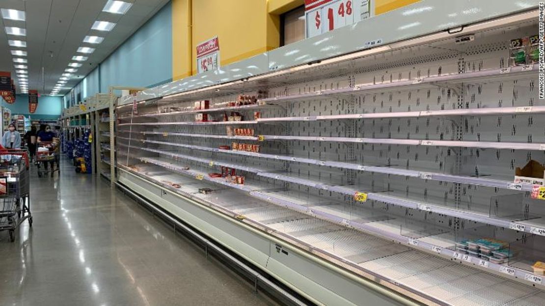 Compradores caminan junto a estantes casi vacíos en un supermercado en Houston, Texas, el 20 de febrero de 2021.