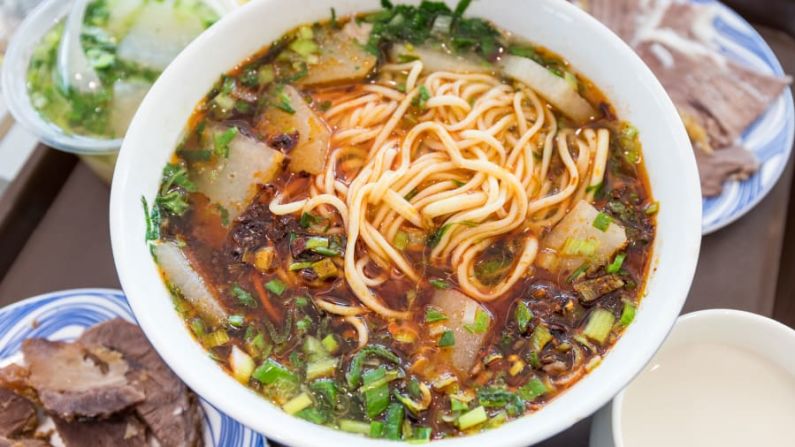 Sopa de fideos con carne de Lanzhou | China: los fideos la mian desmenuzados a mano sirven de base a un tazón de caldo de res que incluye carne tierna, rodajas pálidas de rábano, aceite de chile y hierbas frescas. Shutterstock