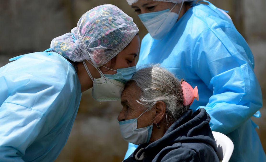 Una mujer mayor es besada por una integrante de los servicios de salud luego de recibir una dosis de la vacuna Sinovac contra el covid-19 en José Joaquín Vargas, residencia de ancianos con discapacidad mental, en Sibate, Colombia.