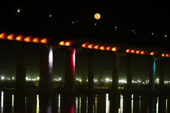 La luna llena se eleva sobre un puente en Allahabad el 27 de febrero de 2021.
