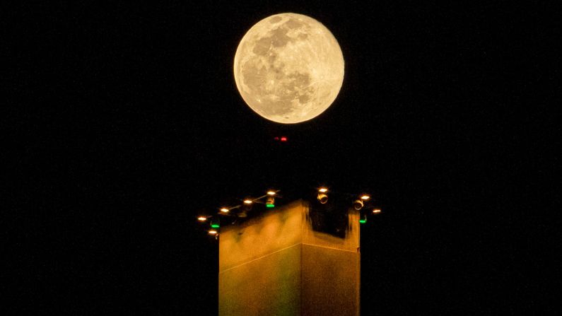 Esta foto tomada el 27 de febrero de 2021 muestra una vista de la luna llena por la noche sobre un puente en la ciudad de Basora, al sur de Iraq.