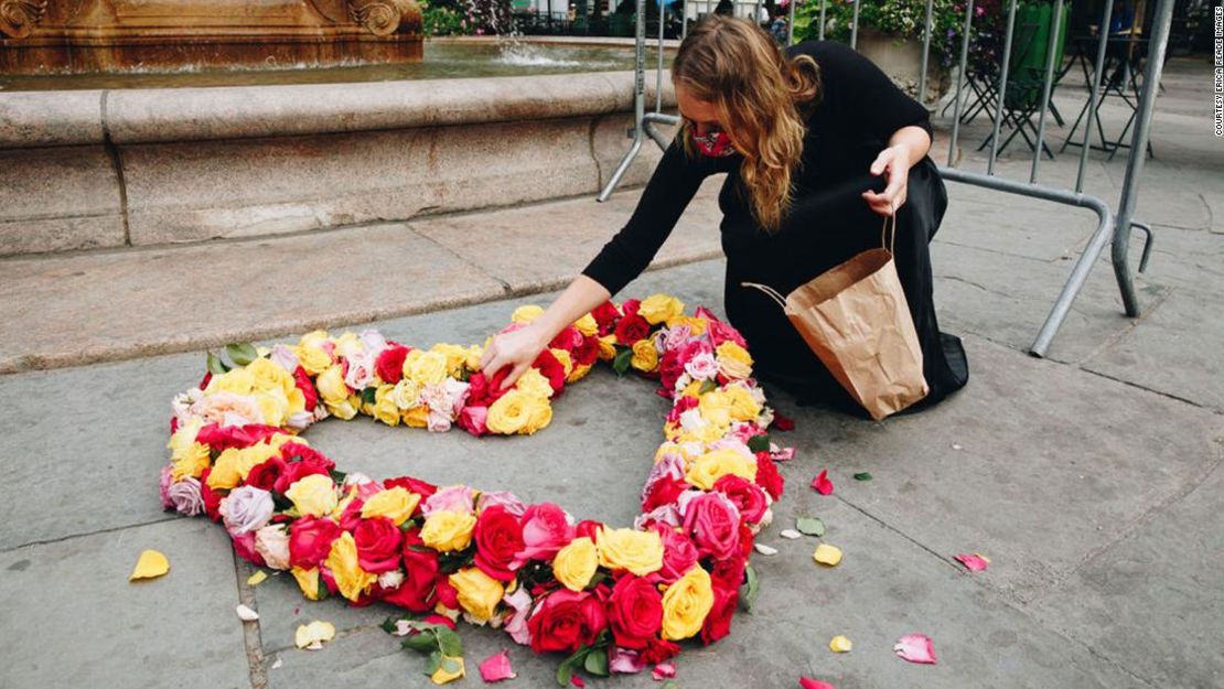 Kristina Libby hace un corazón con flores en el Bryant Park, en la ciudad de Nueva York, para conmemorar a las víctimas del covid-19.