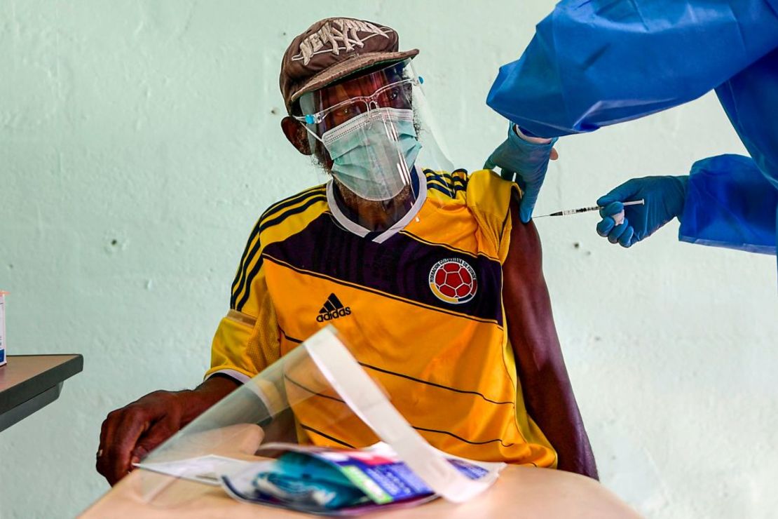 Un hombre mayor usando la camiseta de la selección de fútbol de Colombia recibe una dosis de la vacuna de Pfizer en Ciudad de Panamá.