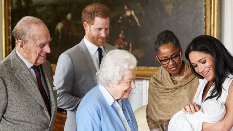 La reina Isabel II mira a su nuevo bisnieto, Archie, en mayo de 2019. El príncipe Felipe está en el extremo izquierdo. La madre de Meghan, Doria Ragland, está junto a ella a la derecha.