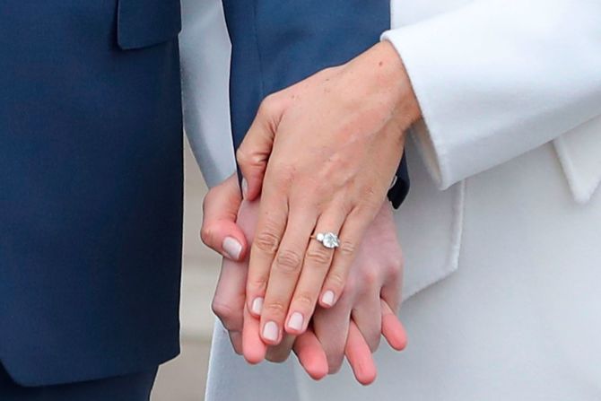 Meghan mostró su anillo de compromiso a periodistas durante una sesión fotográfica en noviembre de 2017. El anillo, diseñado por Harry, presentaba un gran diamante de Botswana y dos diamantes exteriores más pequeños de la colección personal de la difunta madre de Harry, la princesa Diana.