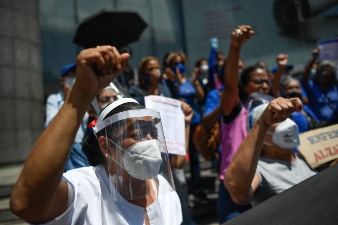 Una enfermera venezolana participa en una manifestación para exigir mayores derechos para las mujeres frente al edificio del Programa de las Naciones Unidas para el Desarrollo en Caracas, el 8 de marzo de 2021, durante el Día Internacional de la Mujer.