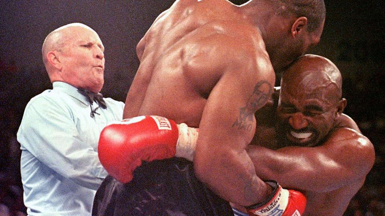 LAS VEGAS, UNITED STATES:  Referee Lane Mills (L) steps in as Evander Holyfield (R) reacts after Mike Tyson bit his ear in the third round of their WBA heavyweight championship fight at the MGM Grand Garden Arena in Las Vegas, NV 28 June. Holyfield won by disqualification after the biting incident.     AFP PHOTO/JEFF HAYNES