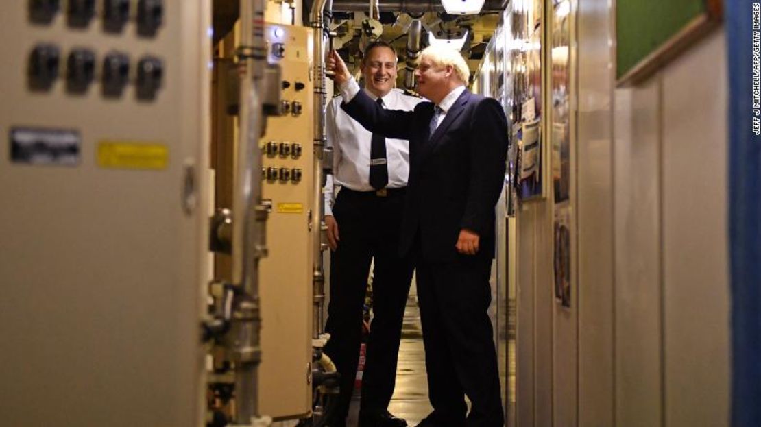 El comandante Justin Codd, a la izquierda, conversa con el primer ministro de Gran Bretaña Boris Johnson a bordo del submarino de clase Vanguard HMS Victorious durante una visita a la base naval de Faslane al norte de Glasgow, Escocia, el 29 de julio de 2019.