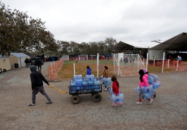 Migrantes que buscan asilo en Estados Unidos cargan jarras de agua vacías en un campamento en Matamoros, México, el 18 de febrero Daniel Becerril / Reuters