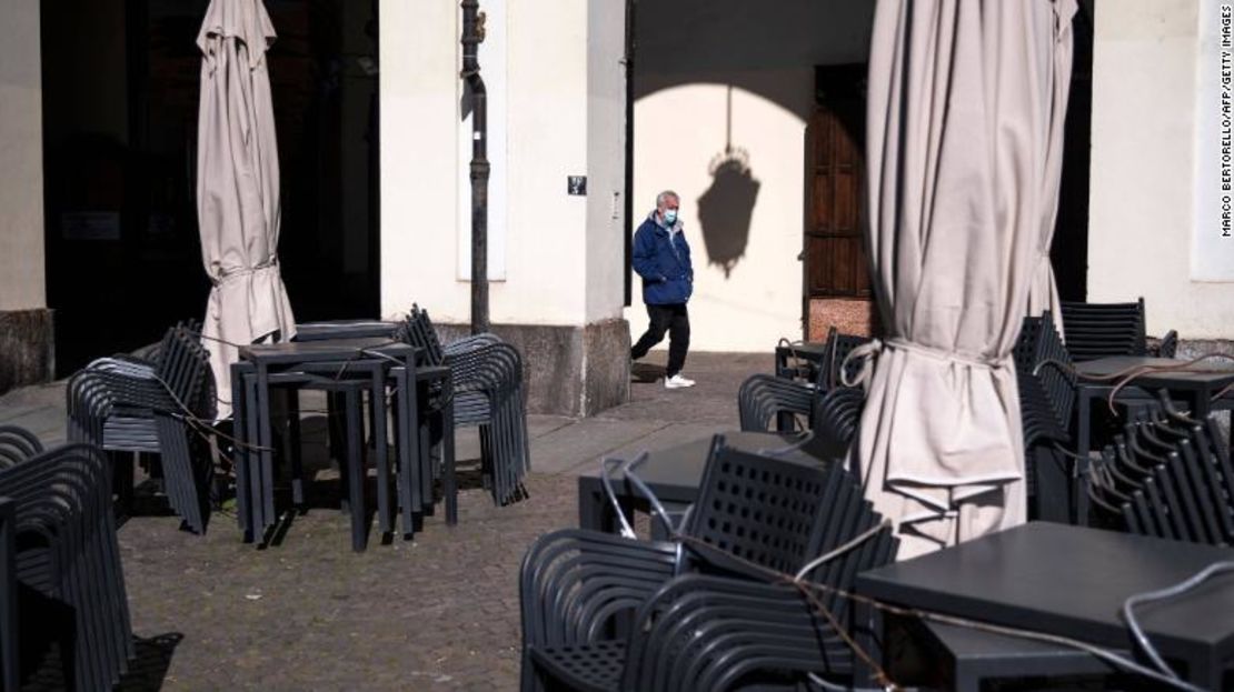 Un hombre camina cerca de un bar cerrado en la Piazza Vittorio de Turín, el 17 de marzo de 2021.