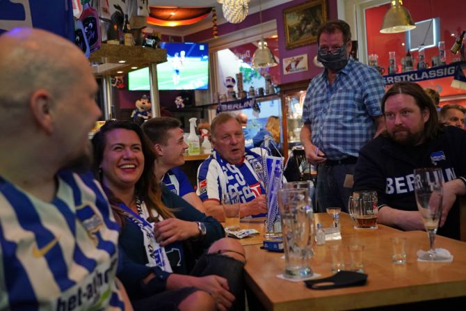 #7: Alemania también logró ser uno de los países más felices del mundo. En la imagen, el dueño del bar Fraenky, en Berlín, atiende a unas personas que acudieron a ver un partido de la Bundesliga en mayo, aún con restricciones por la pandemia.