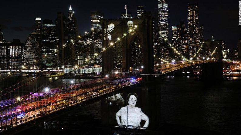En el puente de Brooklyn se proyectan fotos de rostros e víctimas del coronavirus durante una conmemoración en Nueva York el domingo 14 de marzo.