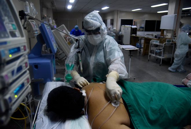 Un trabajador sanitario atiende a un paciente con covid-19 en un hospital de San Lorenzo, Paraguay, el 16 de marzo.