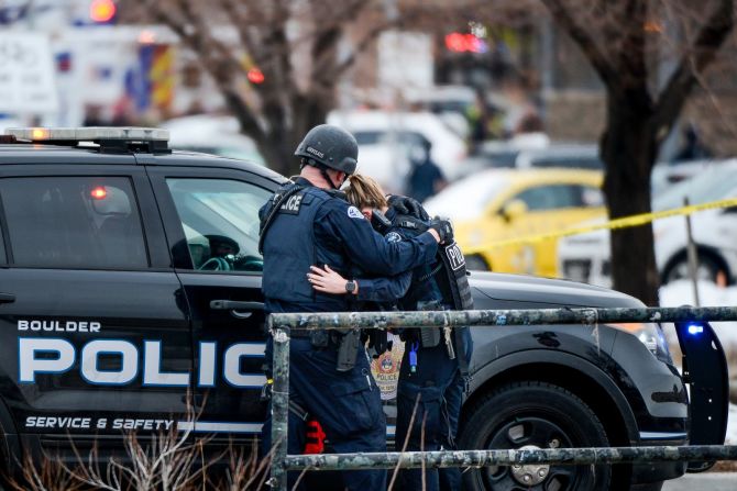 Dos policías se abrazan en el lugar del tiroteo en Boulder, Colorado.