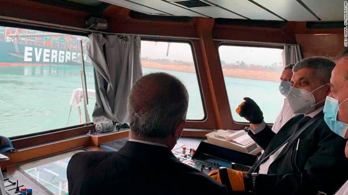 El teniente general Ossama Rabei, jefe de la Autoridad del canal de Suez, segundo a la derecha, habla con otros miembros del personal a bordo de un barco cerca del carguero afectado.