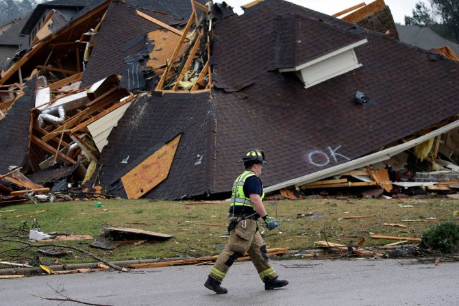 Un bombero pasa junto a una casa dañada en el vecindario de Eagle Point. Butch Dill / AP