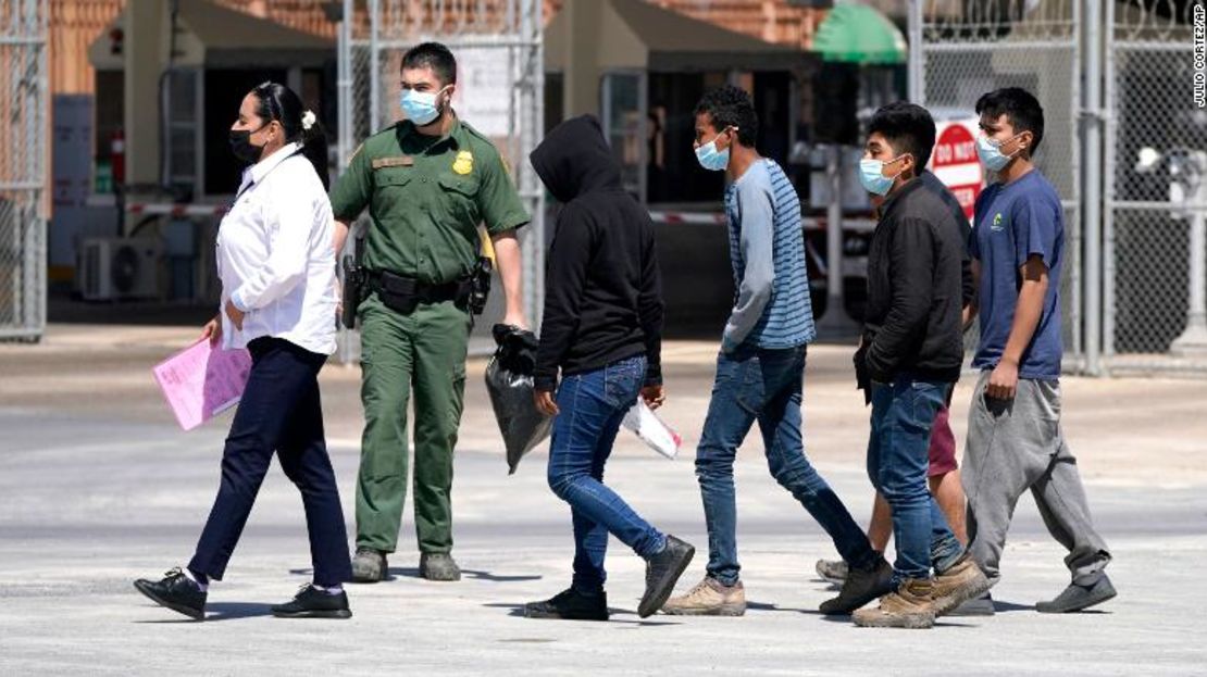 Un agente de Aduanas y Protección de Fronteras de Estados Unidos lidera a un grupo de migrantes que son deportados a Reynosa, México, en el Puente Internacional McAllen-Hidalgo.