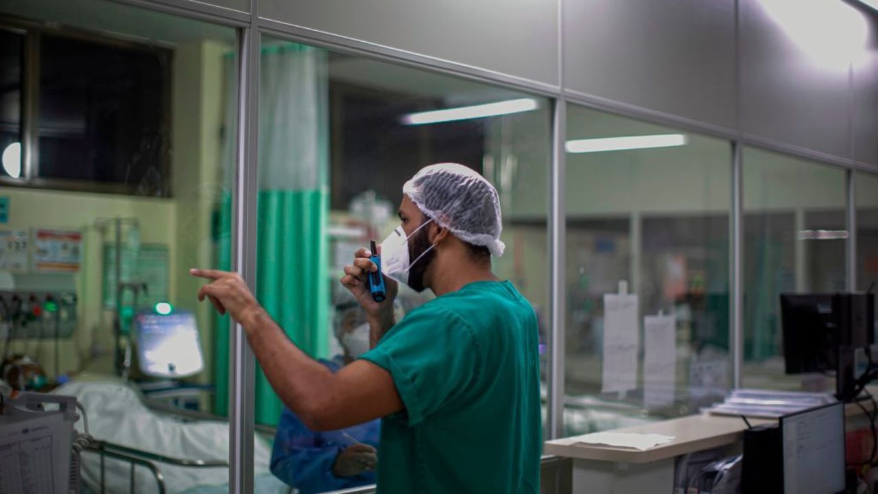 A health care worker uses a walkie talkie to communicate with a colleague taking care of a coronavirus patient at the ICU unit of the Regional Public Hospital of Baixo Amazonas in Santarem, Para state, Brazil, on January 30, 2021. - Para's State Governor Helder Barbalho ordered a lockdown on the region of Baixo Amazonas and Calha Norte of Para state to combate the spread of the coronavirus pandemic. (Photo by TARSO SARRAF / AFP)