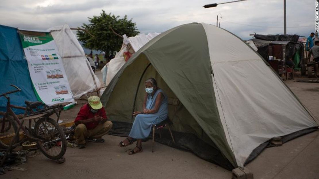 Una anciana sentada afuera de una carpa en Lima, Honduras, donde vive después de perder su hogar en los huracanes Eta e Iota, del año pasado. La devastación de los ciclones y el daño económico por la pandemia de covid-19 se han sumado a las fuerzas que impulsan a los hondureños a migrar.