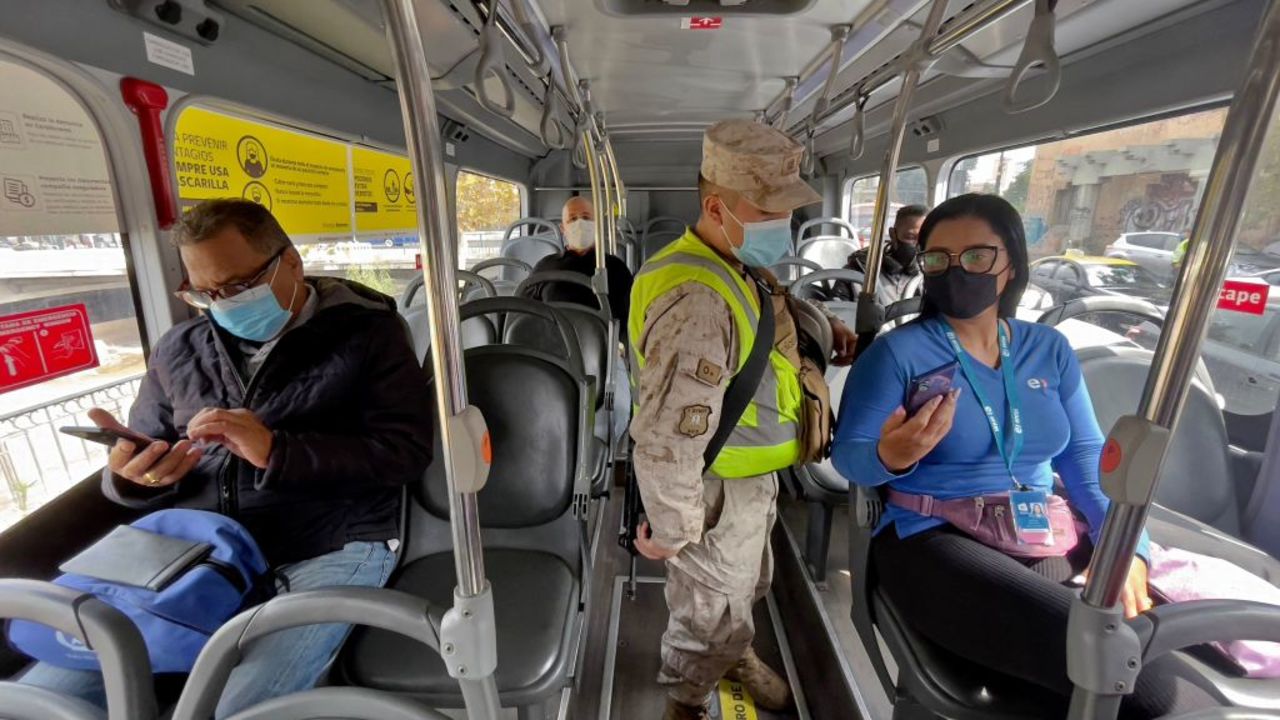 A soldier checks passengers on a bus at a checkpoint in Santiago, on March 25, 2021, amid the COVID-19 pandemic. - Almost 14 million people, about 70% of the population, began a new quarantine in Chile this Thursday, due to a sharp increase in new cases of covid-19, which once again put the health system in check, despite an impressive vaccination campaign. Chilean authorities have been implementing, among other measures, a selective quarantine in areas with a high incidence of infection and have placed an emphasis on controlling the pandemic by mass screening. (Photo by MARTIN BERNETTI / AFP)