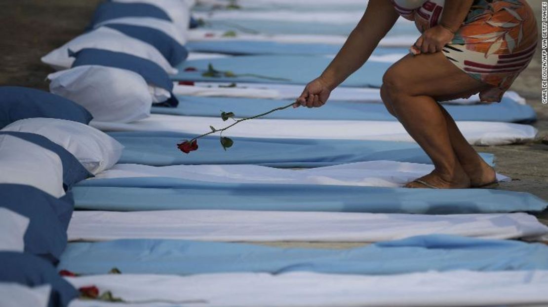 Una mujer coloca una rosa sobre un colchón que simboliza a las víctimas del covid-19 durante una protesta frente a un hospital en Río de Janeiro, Brasil, el 24 de marzo de 2021.