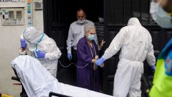 Healthcare workers of the Medical Emergency Services of Madrid (SUMMA 112) UVI-6 unit wearing protective suits escort suspected COVID-19 patient Asuncion (C) to a hospital after examining her symptoms at home in Madrid on April 19, 2020. - Spain imposed a tight lockdown on March 14 to slow the spread of the virus which has so far killed more than 20,800 people, the third-highest number of deaths in the world after the United States and Italy. (Photo by OSCAR DEL POZO / AFP)