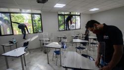 Workers place acrylic shields as a preventive measure against the spread of the novel coronavirus COVID-19 on desks at a Motolinia school classroom in Mexico City, on July 15, 2020, ahead of the reopening of educational facilities. (Photo by Pedro PARDO / AFP)