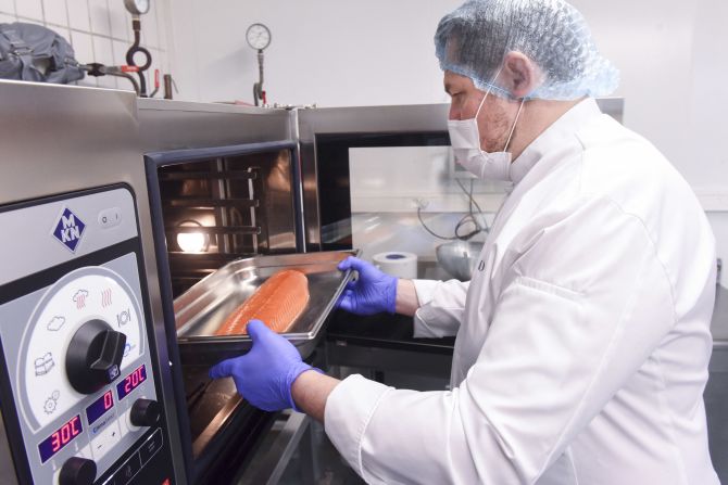 Un chef del equipo de Ducasse prepara un salmón cocido a baja temperatura, mismo que formará parte de los platillos que irán al espacio. Crédito: Sebastien SALOM-GOMIS / AFP vía Getty Images.