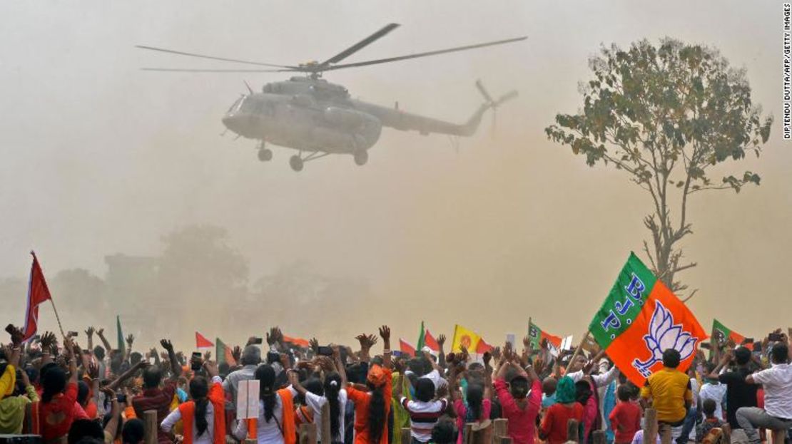 Seguidores del Partido Bharatiya Janata (BJP) saludan a un helicóptero que transporta al primer ministro de India, Narendra Modi, a su llegada a un mitin en Kawakhali, Bengala Occidental, el 10 de abril.