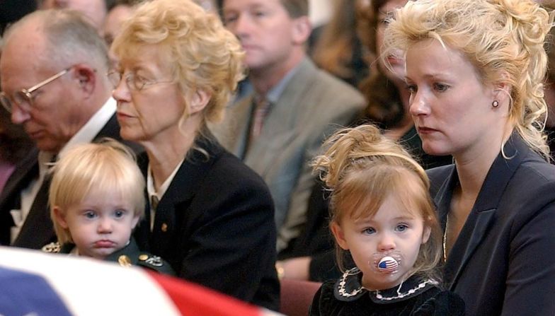 Renae Chapman carga a su hija de 2 años, Amanda, durante el funeral de su esposo, el sargento del ejército. Nathan R. Chapman de primera clase, en Fort Lewis, Washington, en enero de 2002. Chapman fue el primer soldado estadounidense que murió por fuego enemigo durante la guerra en Afganistán.