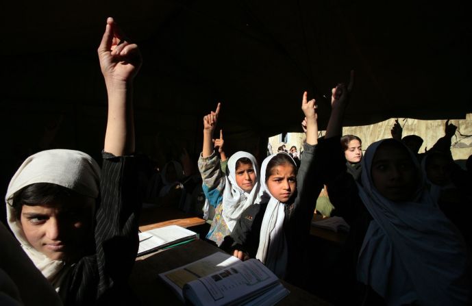 Niñas de la escuela secundaria Bibi Mahroo levantan la mano durante una clase de inglés en Kabul en noviembre de 2006. Después de la caída de los talibanes, millones de niñas afganas pudieron asistir a la escuela y recibir la educación que sus madres no pudieron.