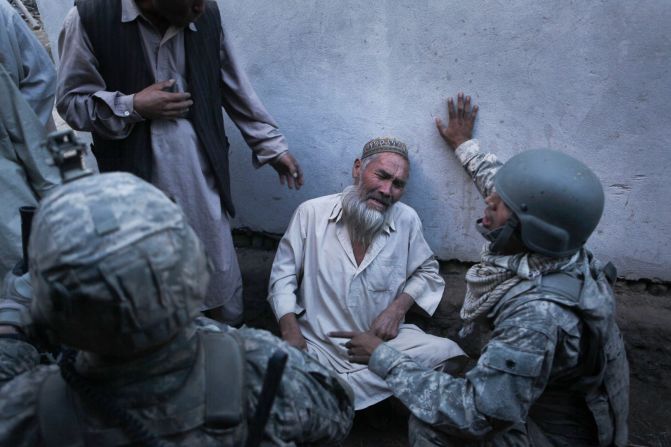 Un hombre llora mientras habla con soldados estadounidenses en Naghma Bazaar, Afganistán, en septiembre de 2010. El hombre dijo que combatientes talibanes entraron a la fuerza en su casa y exigieron comida y leche antes de entrar en un tiroteo con los soldados estadounidenses.