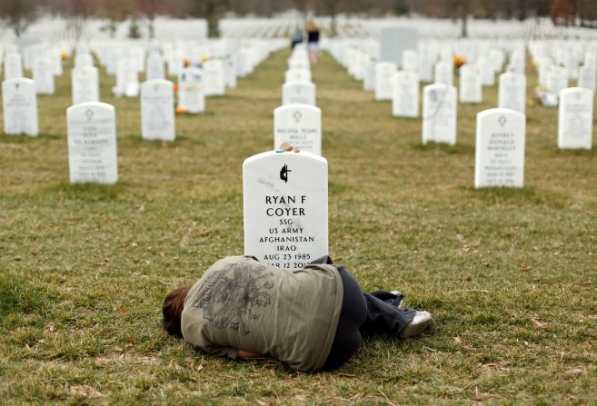 Lesleigh Coyer se acurruca frente a la tumba de su hermano, el sargento del Ejército Ryan Coyer, en el cementerio nacional de Arlington de Virginia en marzo de 2013. Él murió por complicaciones de una lesión sufrida en Afganistán.