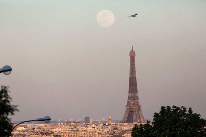 La luna sobre la Torre Eiffel en París, Francia.
