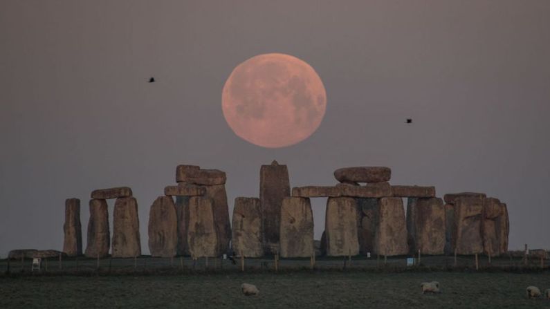 La luna se observa detrás de Stonehenge, en Amesbury, Inglaterra.