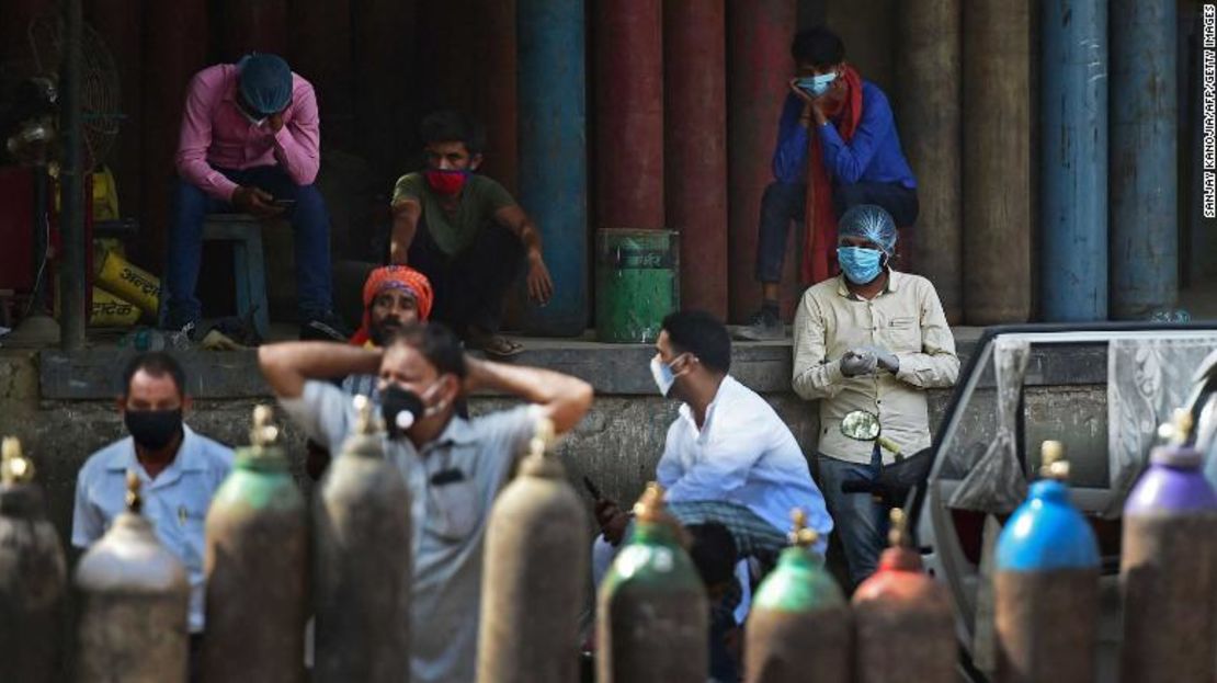 Personas esperan para rellenar sus cilindros de oxígeno médico para los pacientes con coronavirus en una estación de recarga en Allahabad.