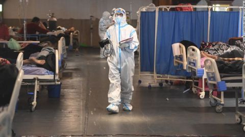 Un trabajador de la salud que usa un equipo de protección personal (EPP) camina dentro de un salón de banquetes convertido temporalmente en un pabellón Covid-19 en Nueva Delhi.